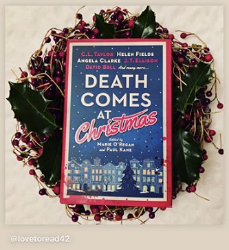 photograph of a copy of Death Comes at Christmas, edited by Marie O'Regan and Paul Kane, lying on a wreath of holly berries and leaves, on a cream background