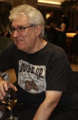 photograph of a smiling Paul Kane with a glass of whiskey