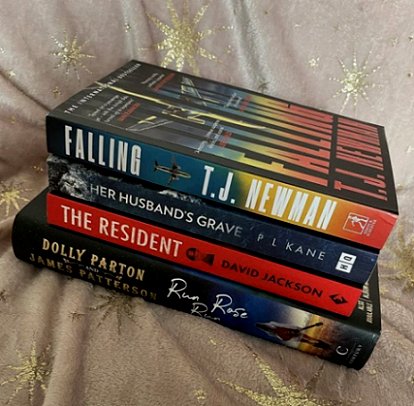 Stack of books including Her Husband's Grave by P L Kane